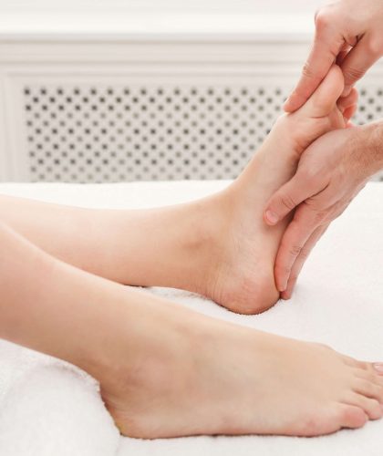 Leg massage. Physiotherapist pressing specific spots on female foot. Professional health and wellness acupressure manipulations, copy space, closeup